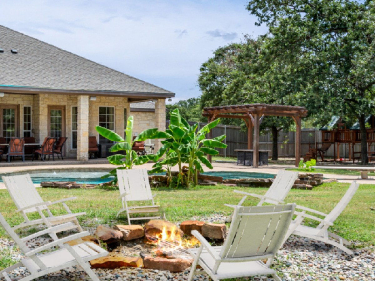 a house with a lawn in front of a picnic table