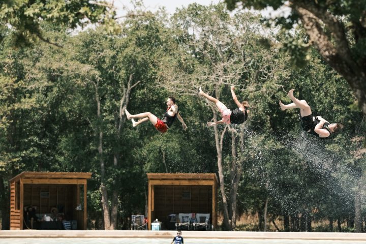 a group of people jumping in the water